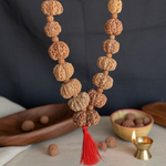 Load image into Gallery viewer, Natural brown Rudraksha beads mala with intricate Mukhi textures, finished with a vibrant red tassel.